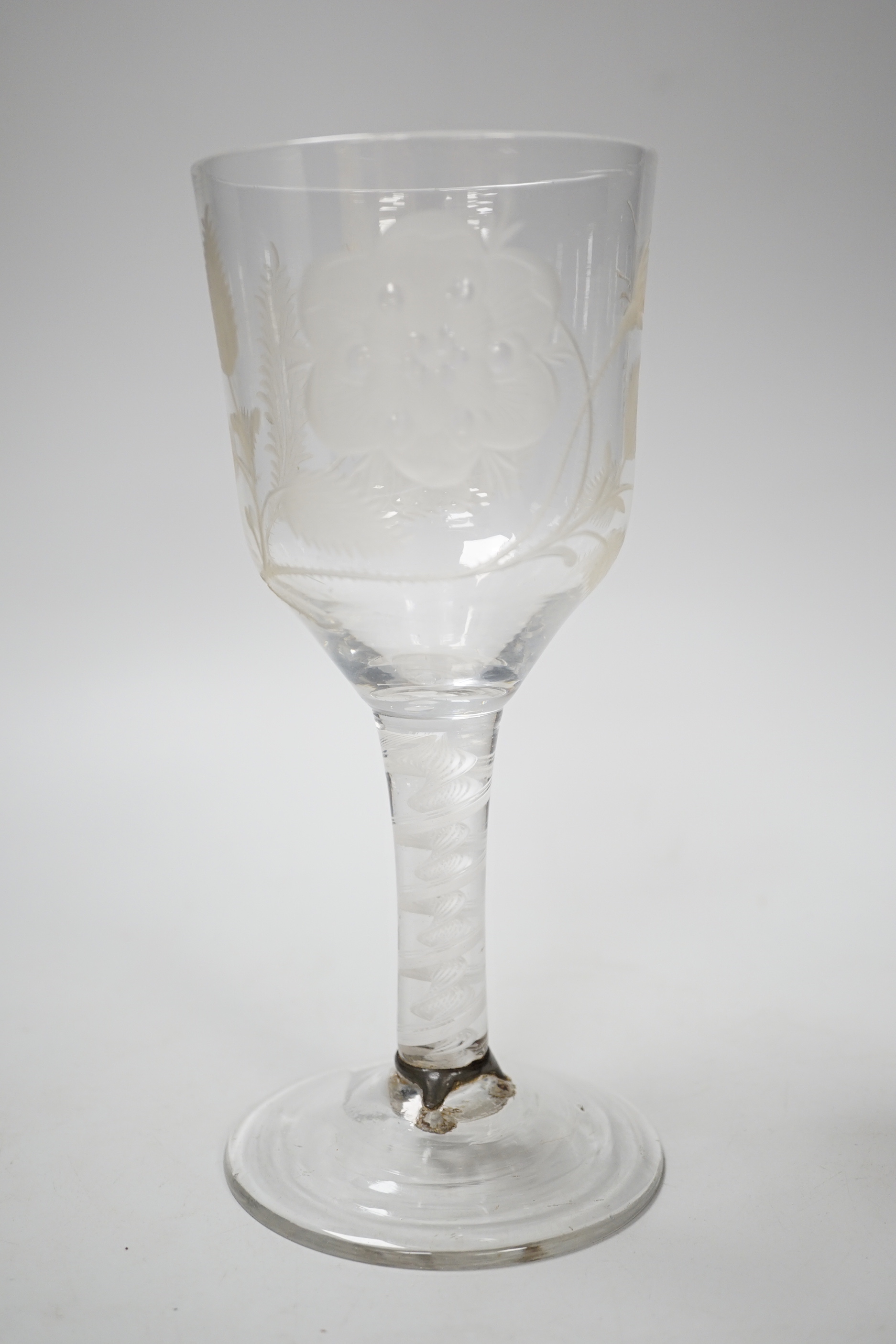 An English lead crystal Jacobite goblet, c.1750-60, bowl of ogee form, engraved with open and one closed rose and thistle, DSOT stem and plain foot with rough pontil, central gauze and multi spiral threads, tool marked,